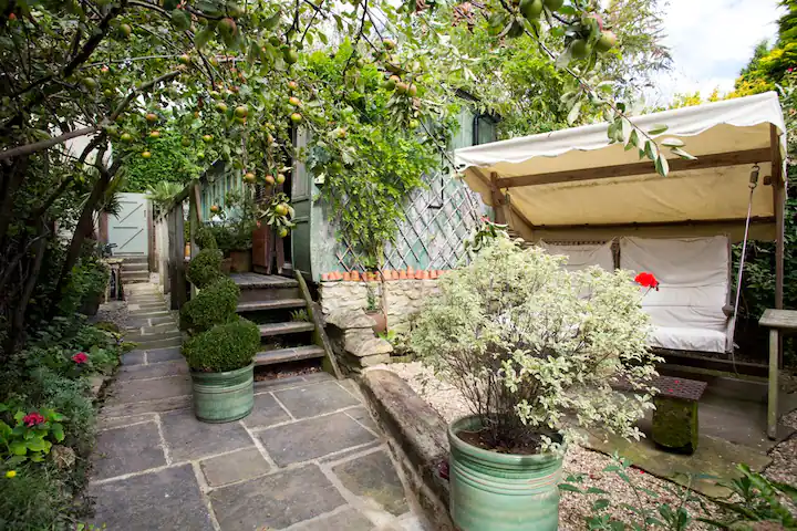 Outside the Helmsley Railway Carriage, there is a swing and lots of plants