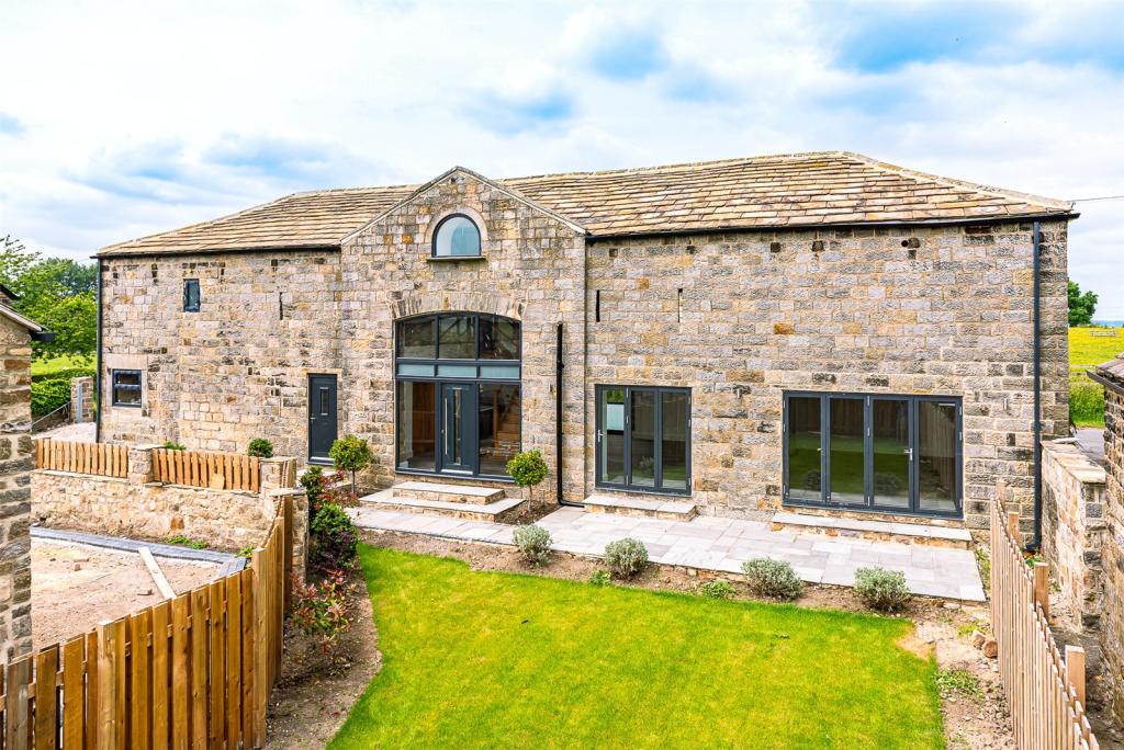 outside the barn conversion showing grass and house