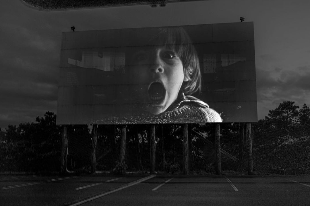 open air cinema with a scared child on the screen