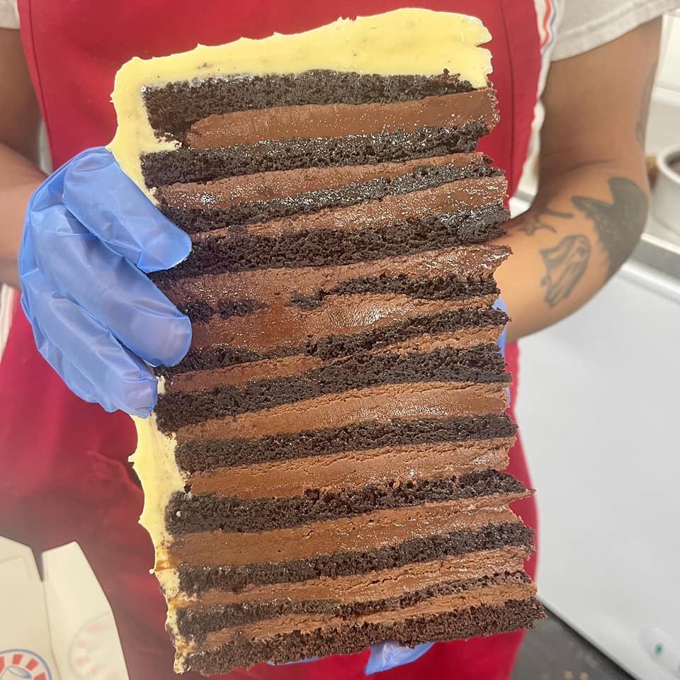 huge twelve sliced cake held up by hand