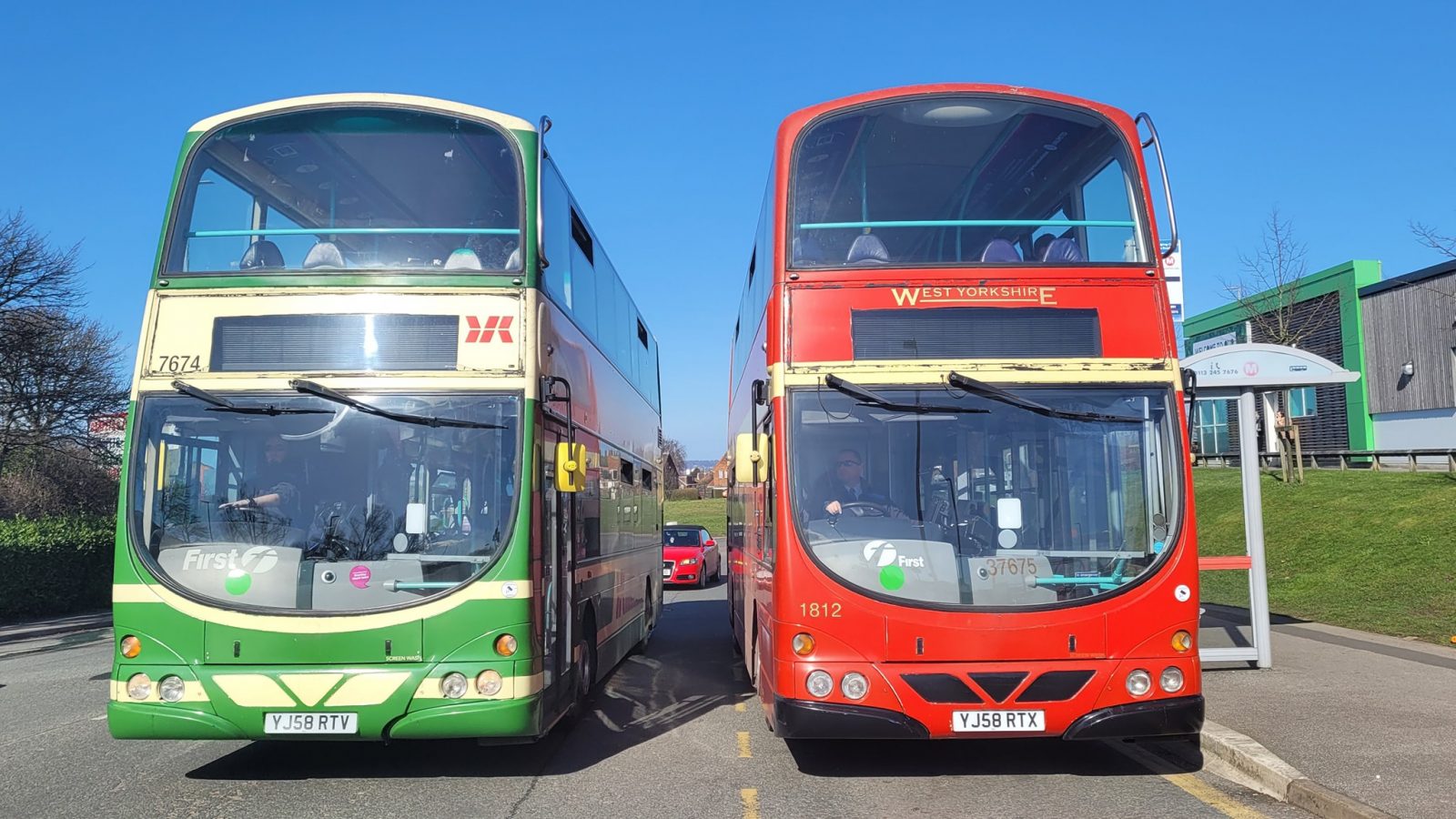 two buses side by side at a bus stop