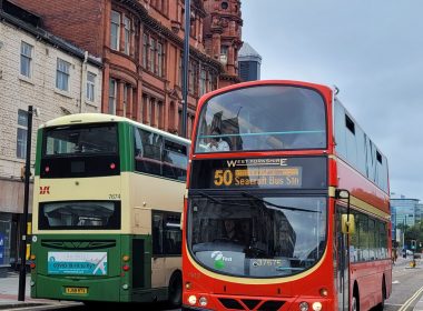 two buses, one red and one yellow and green