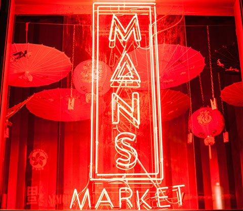 neon sign with mans market logo