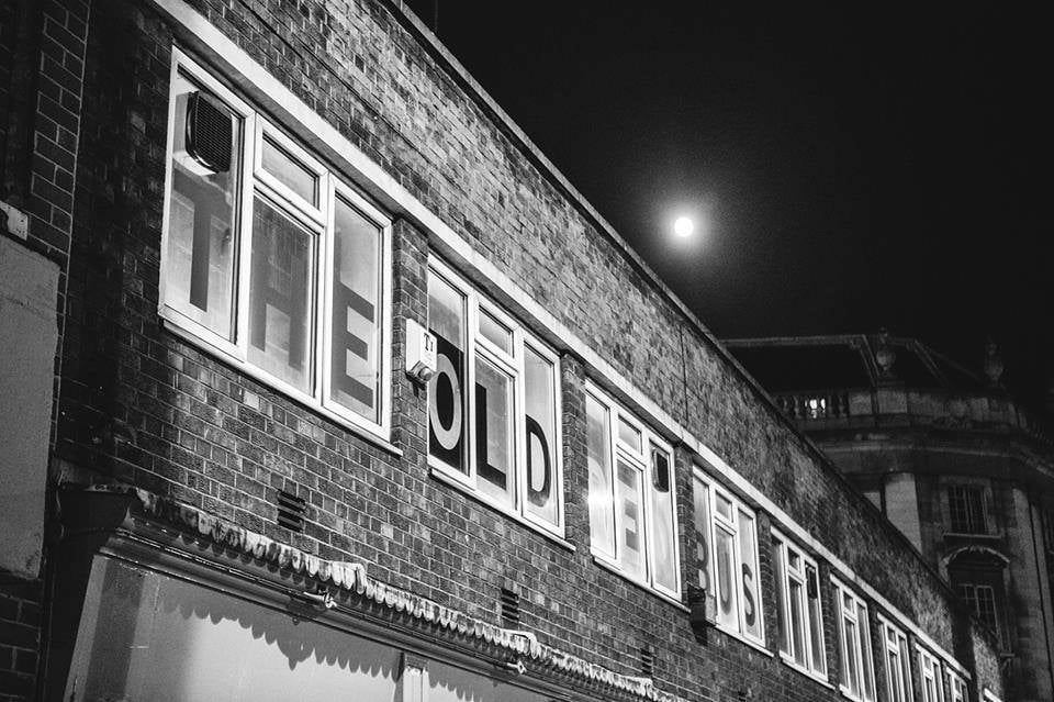 outside of the bar with brick walls and a 'The Old Red Bus Station' sign 