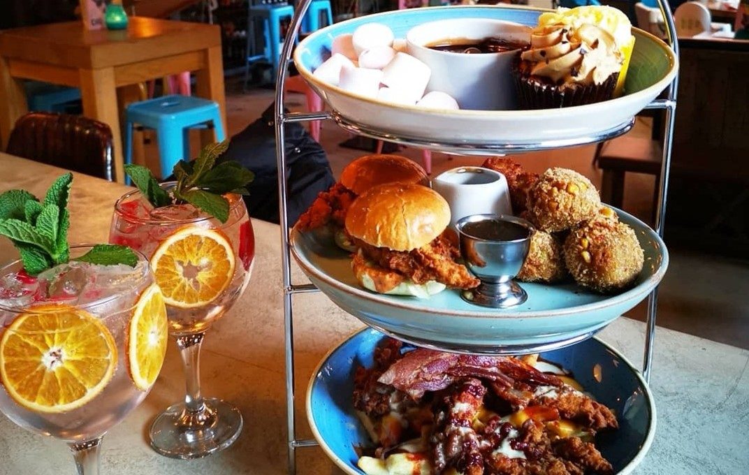 three tiers of chicken, chips and sweet treats on