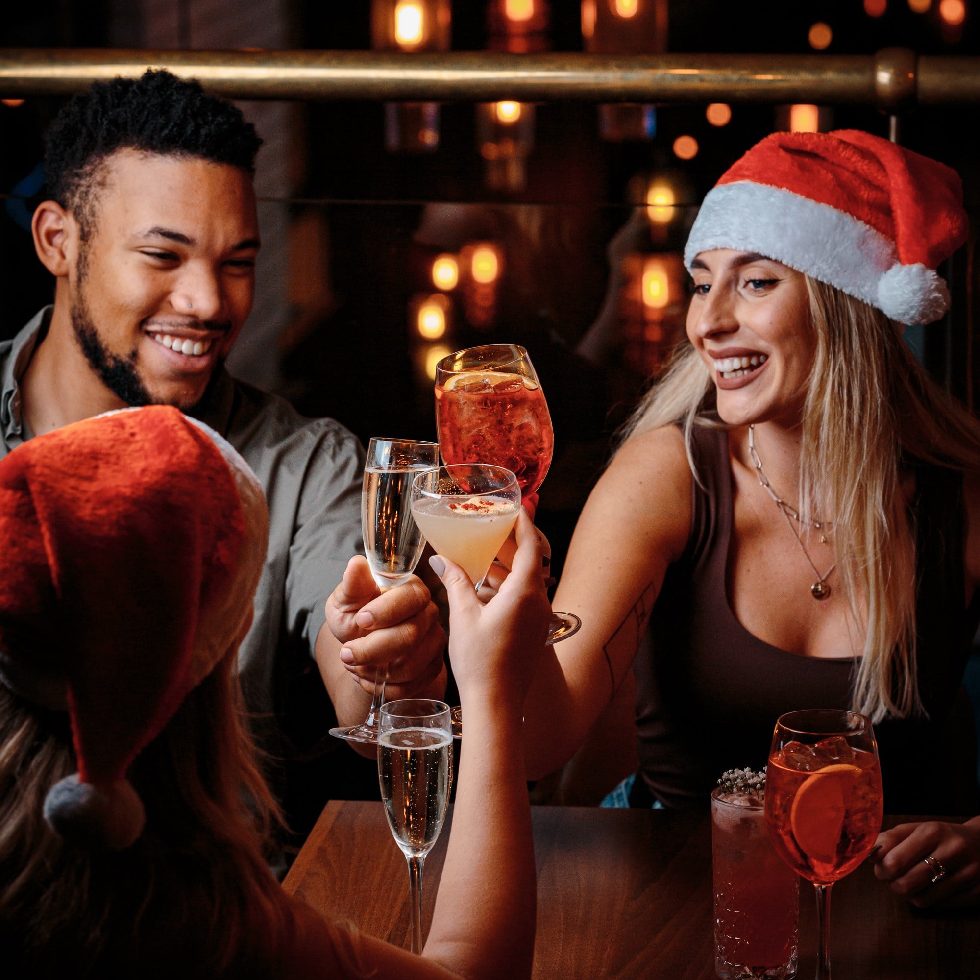 people drinking with santa hats on in Manahatta at a Christmas bottomless