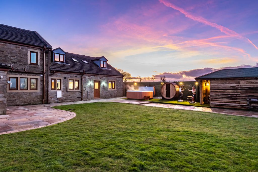 house at sunset with a hot tub and sauna in the corner.