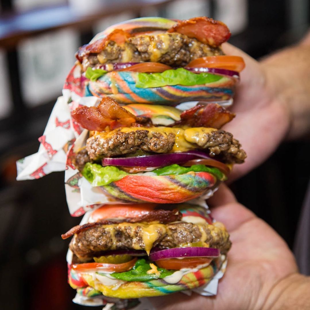 three burgers with rainbow buns.
