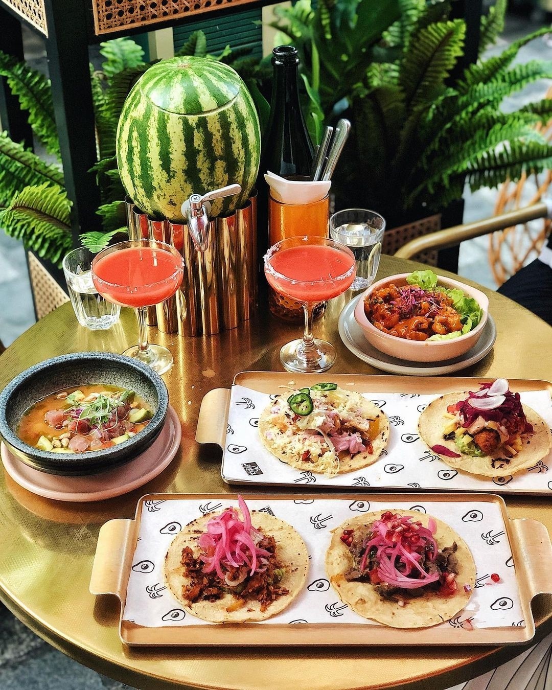 Tacos and margaritas on a table.
