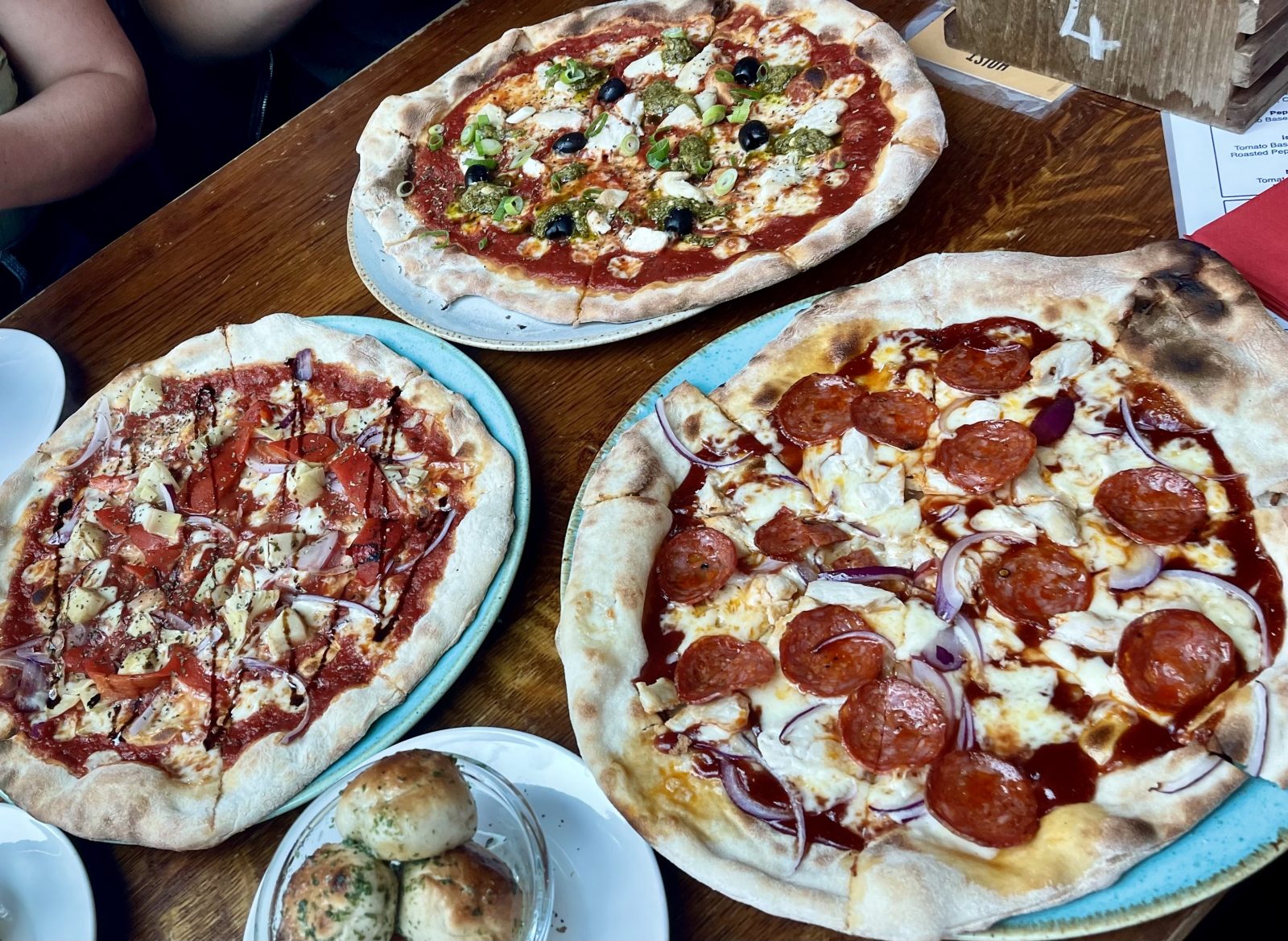pizzas and dough balls on table.