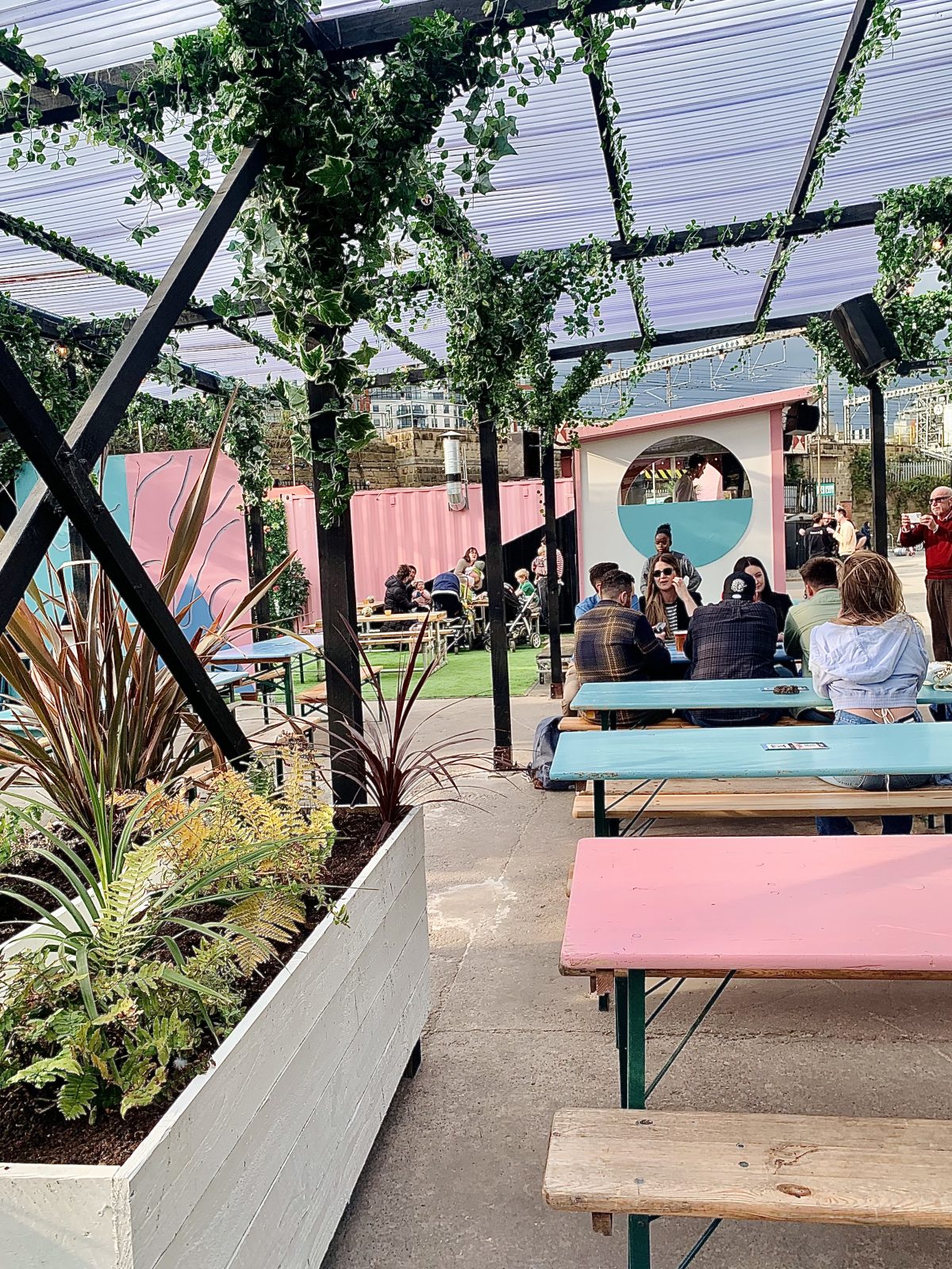 beer garden with pastel coloured tables.
