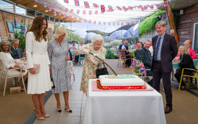 The royal family around a giant cake.