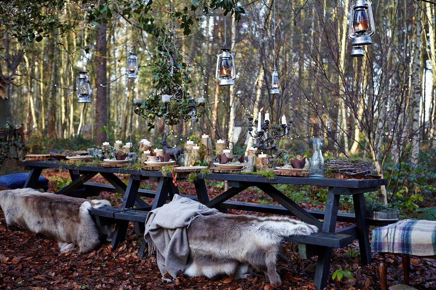 A picnic bench with hanging lanterns above.