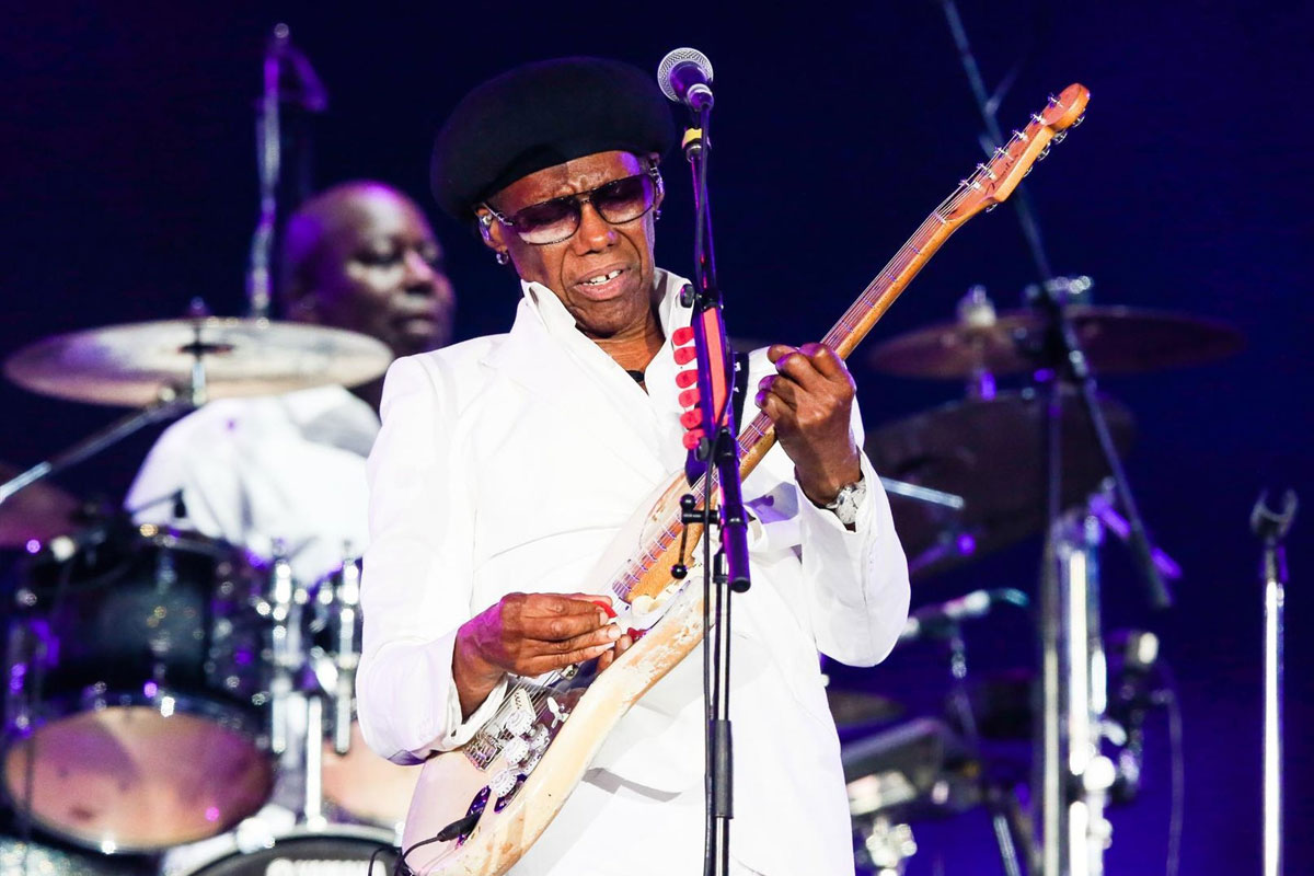 Nile Rodgers on stage performing. 