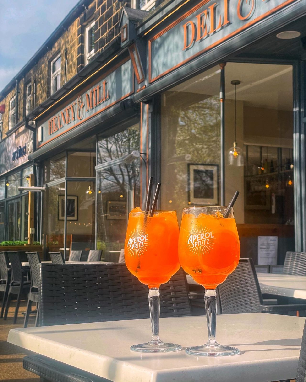 Two aperol spritz on a table at Heaney & Mill. 