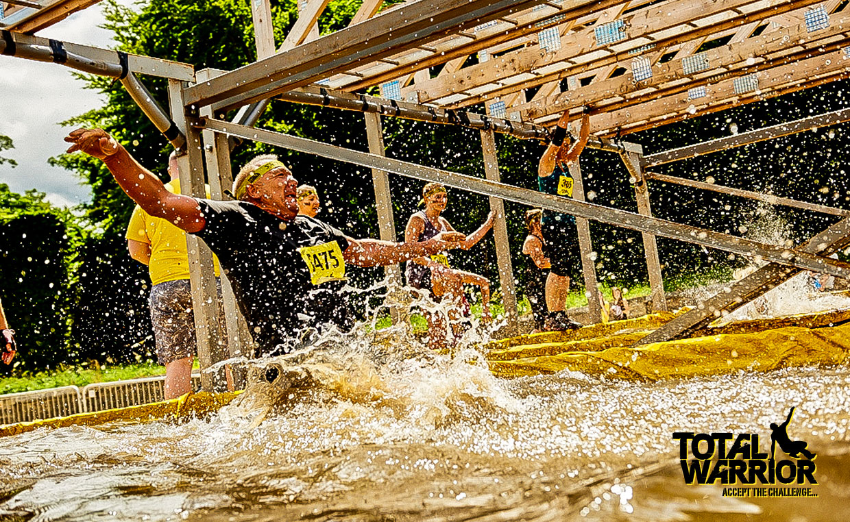 People jumping over the pond at Total Warrior.