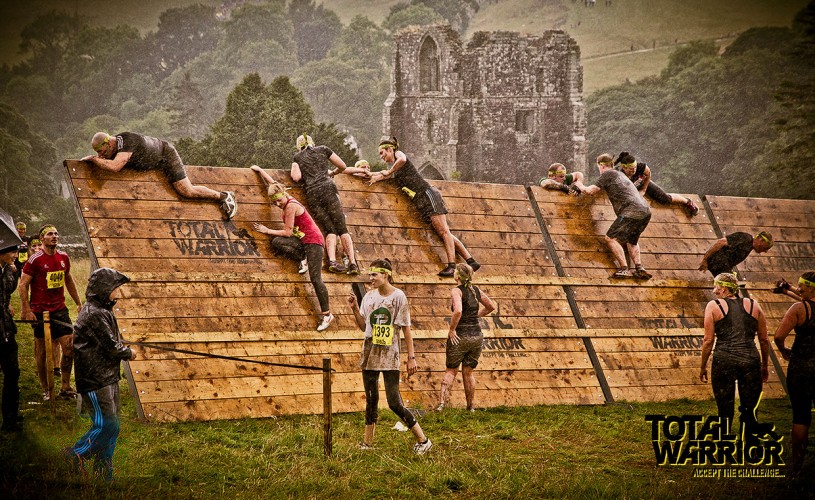 Contestants climbing over the wall at Total Warrior.