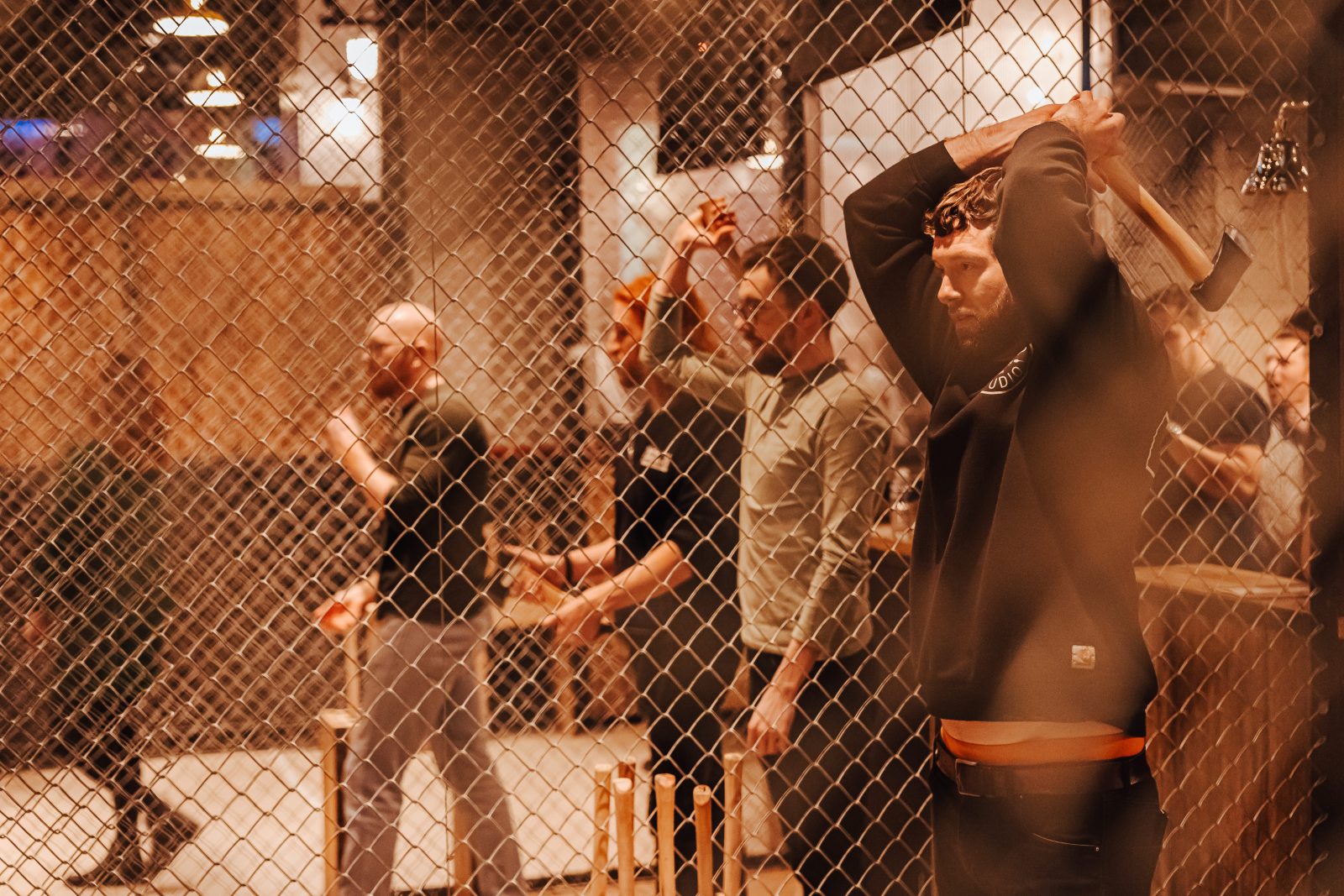 A group of people axe-throwing. 