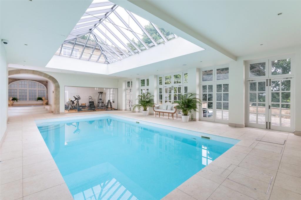 The indoor swimming pool has a glass ceiling view that floods the space with natural light.