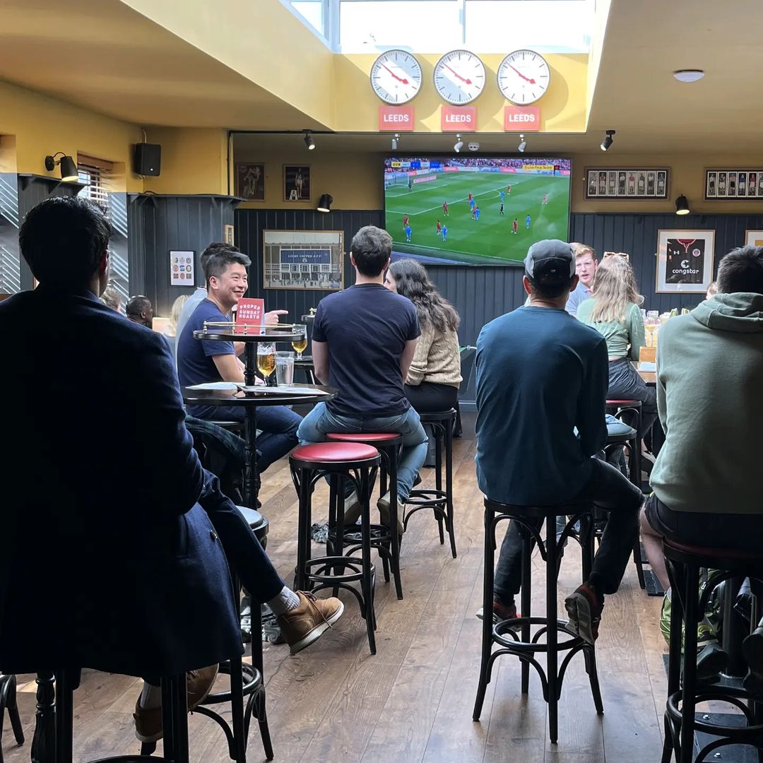 people sat at tables watching TV.