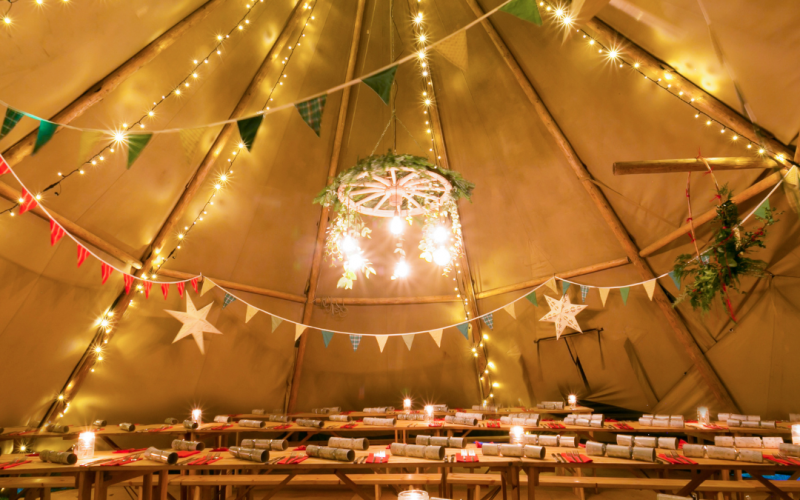 Inside a tipi with crackers and tables.