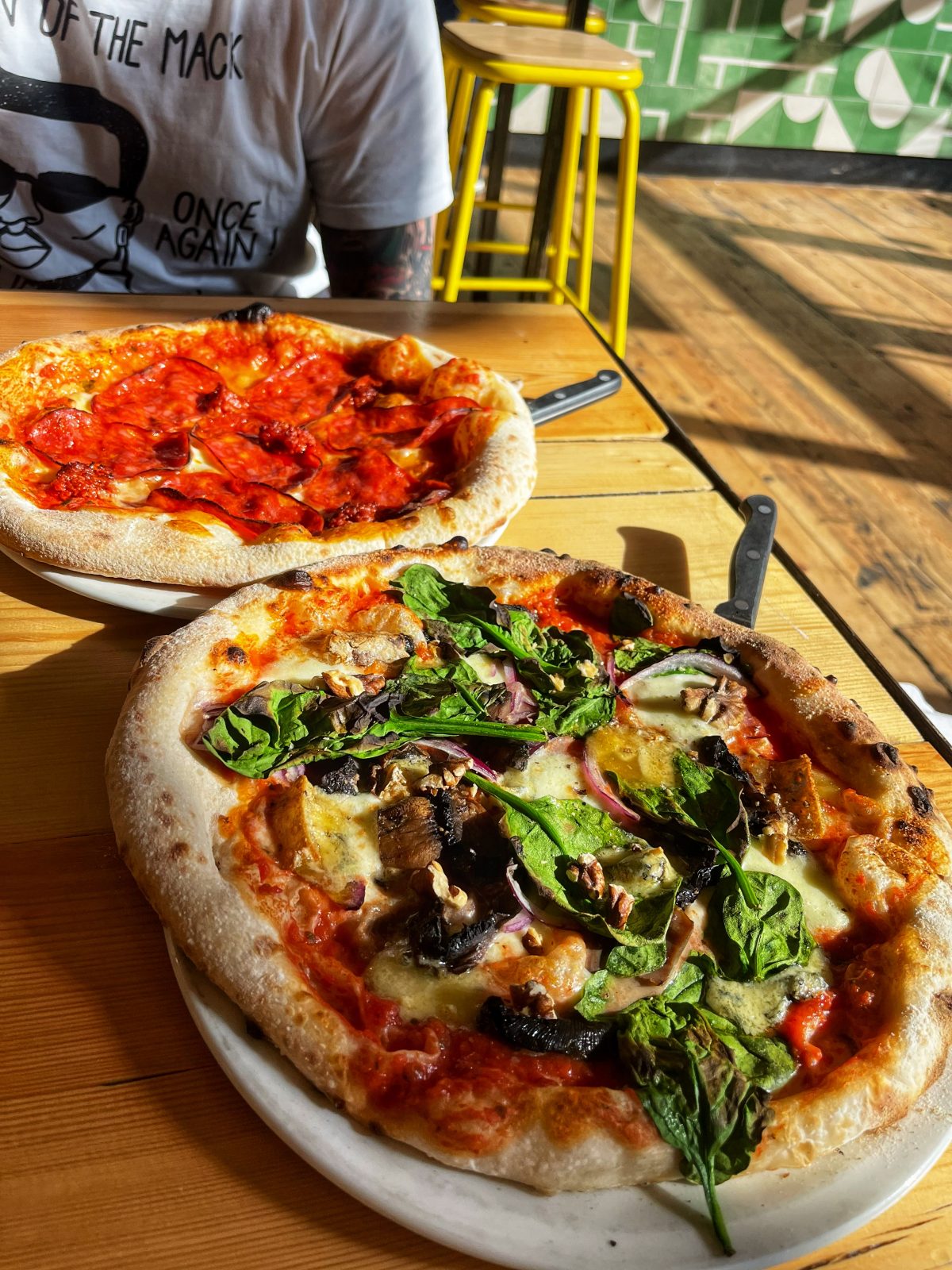 two pizzas in the sunshine.