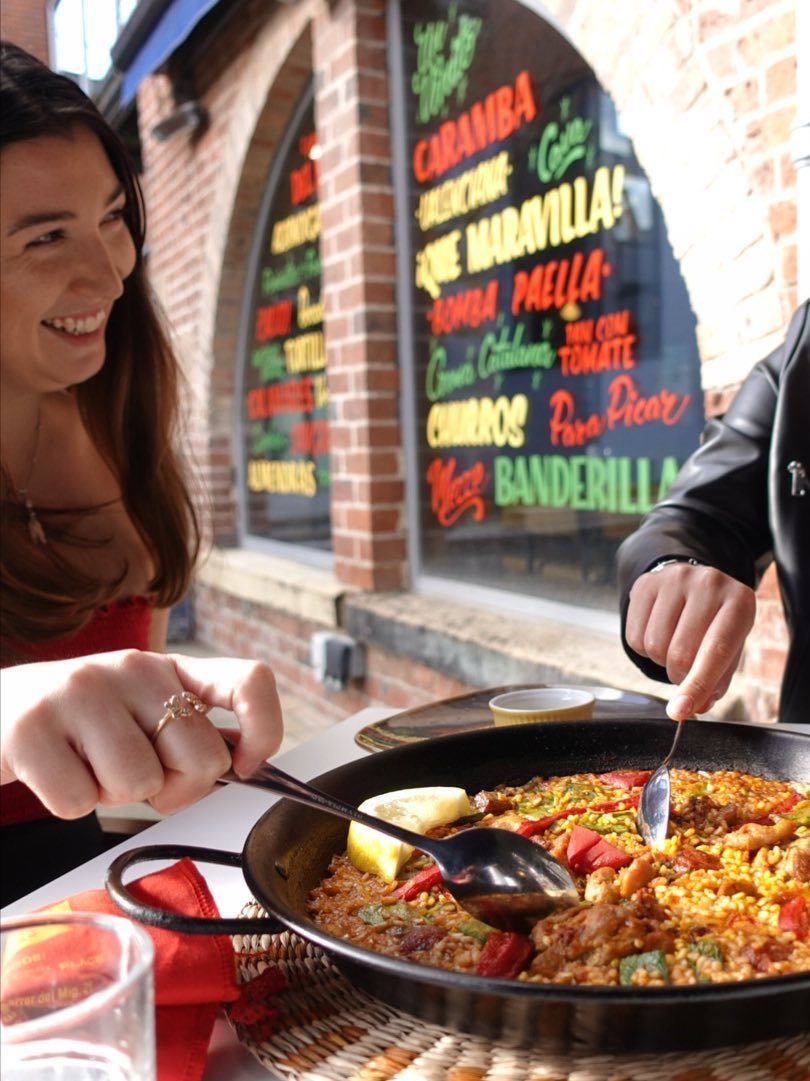 Two people sharing paella.