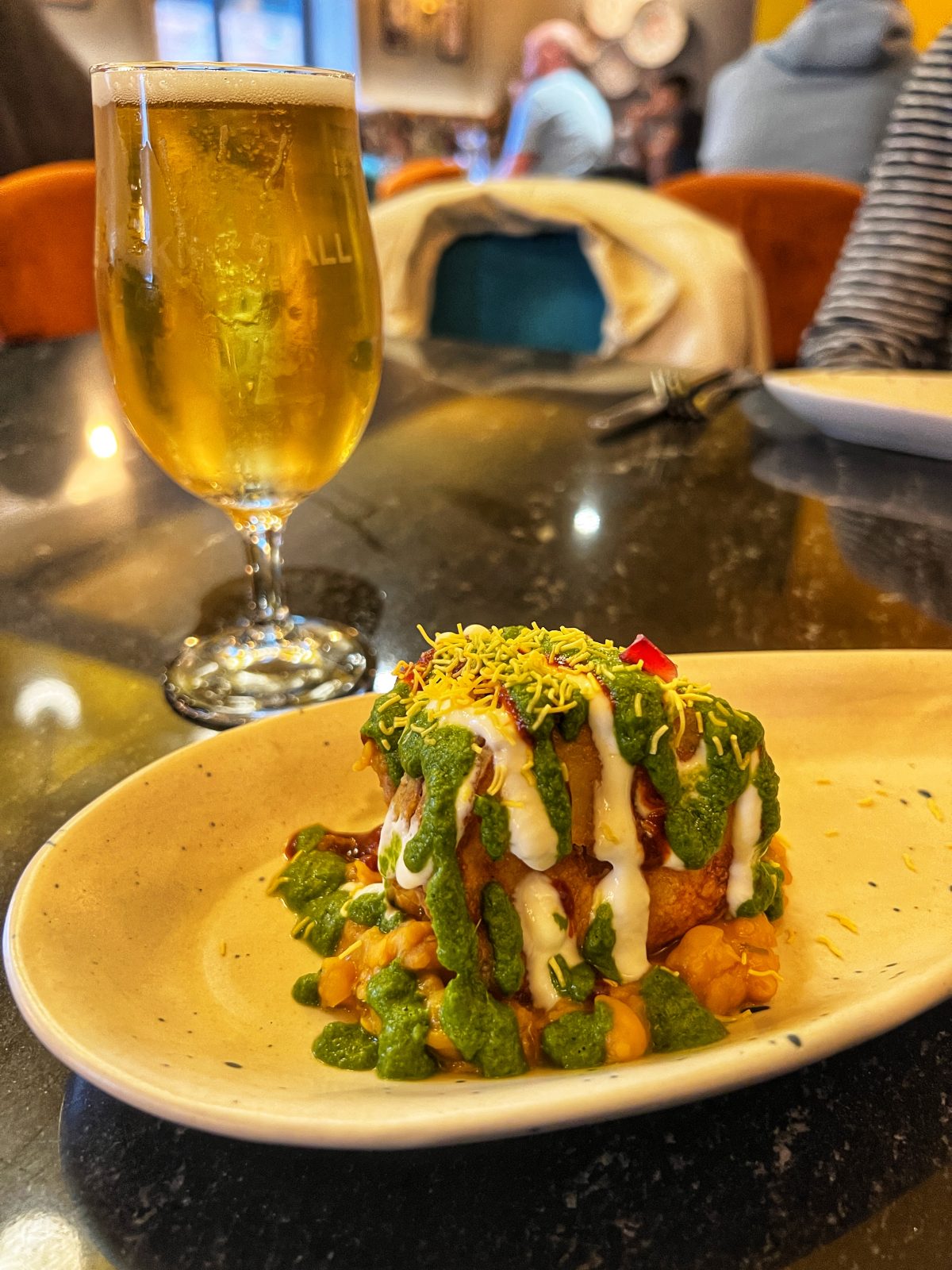 plate with orange, green and white sauces.