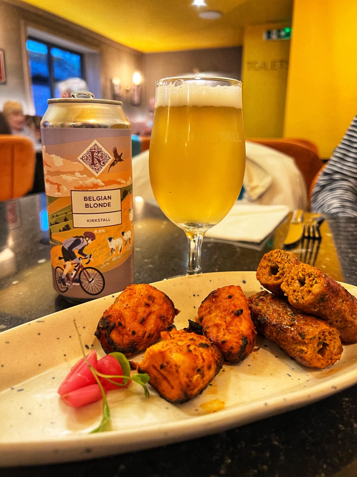 plate of food with beer in background.