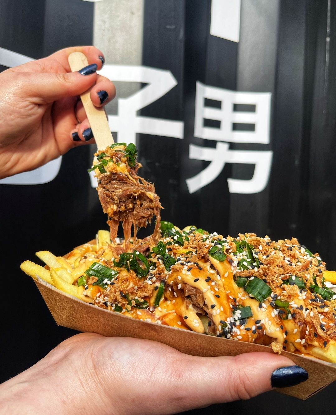 Little Bao Boy beef loaded fries held up with a fork.