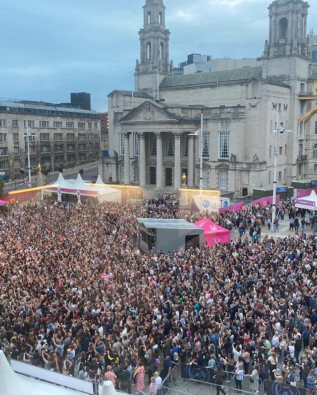 Millennium square in Leeds with a full crowd of people.