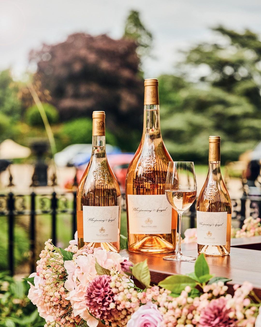 A magnum and two regular sized bottles of rosé on a table.