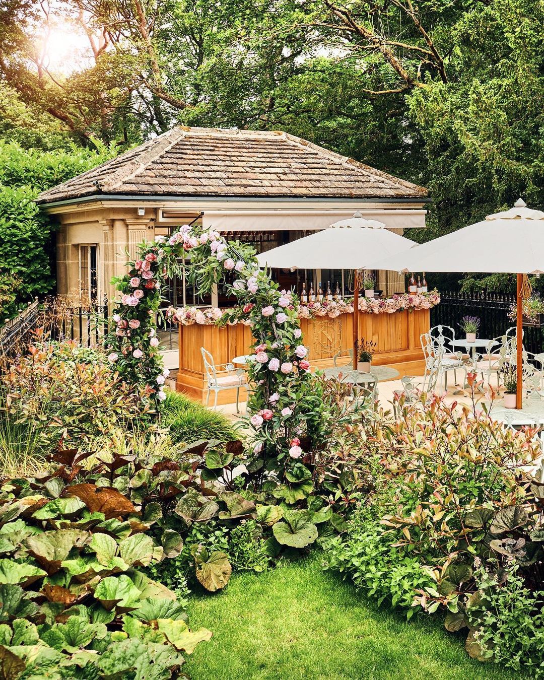 A beautiful green garden with mint green bistro sets. 