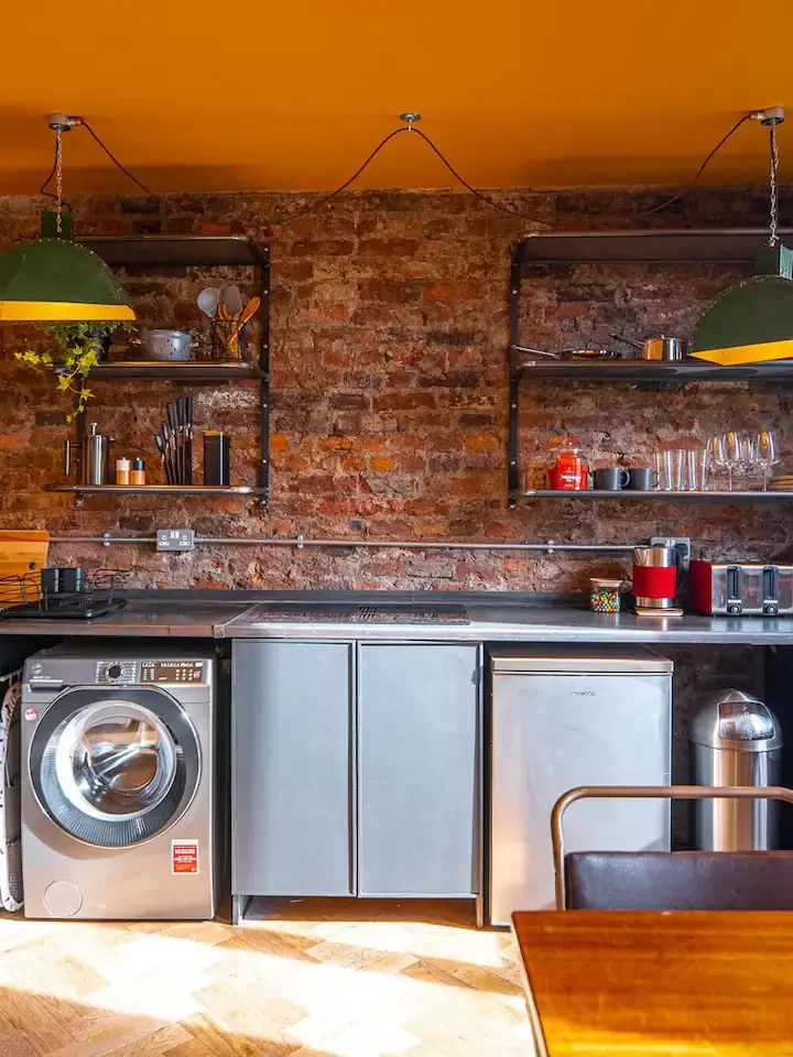A kitchen with a brick wall interior. 