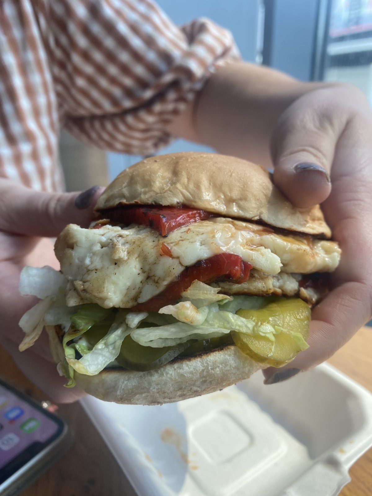 A burger with red pepper and halloumi.