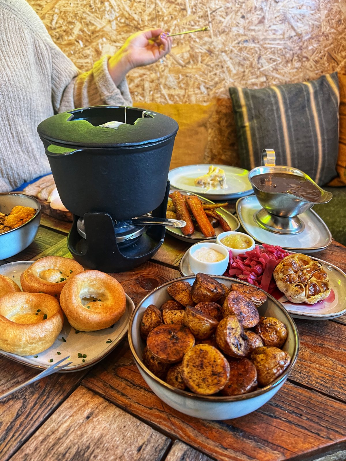 roast dinner plates with Yorkshire puddings and roast potatoes with a fondue pot.