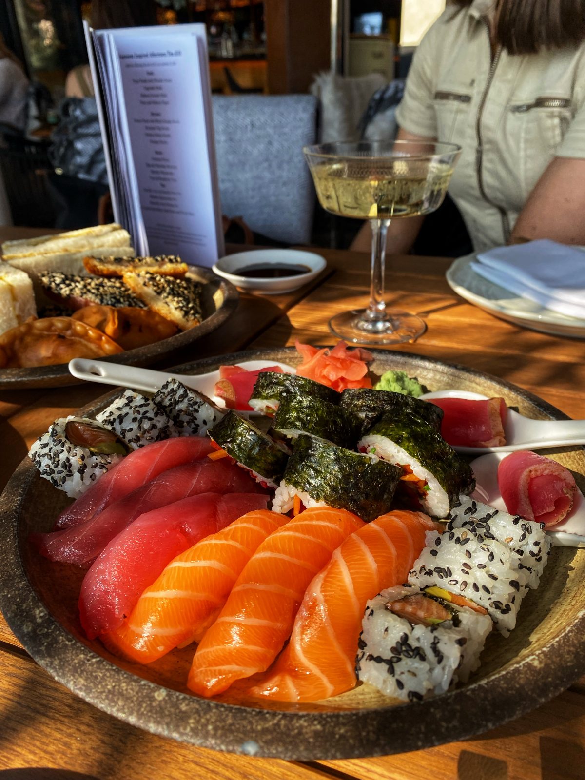 plate of sushi with salmon and small rolls.