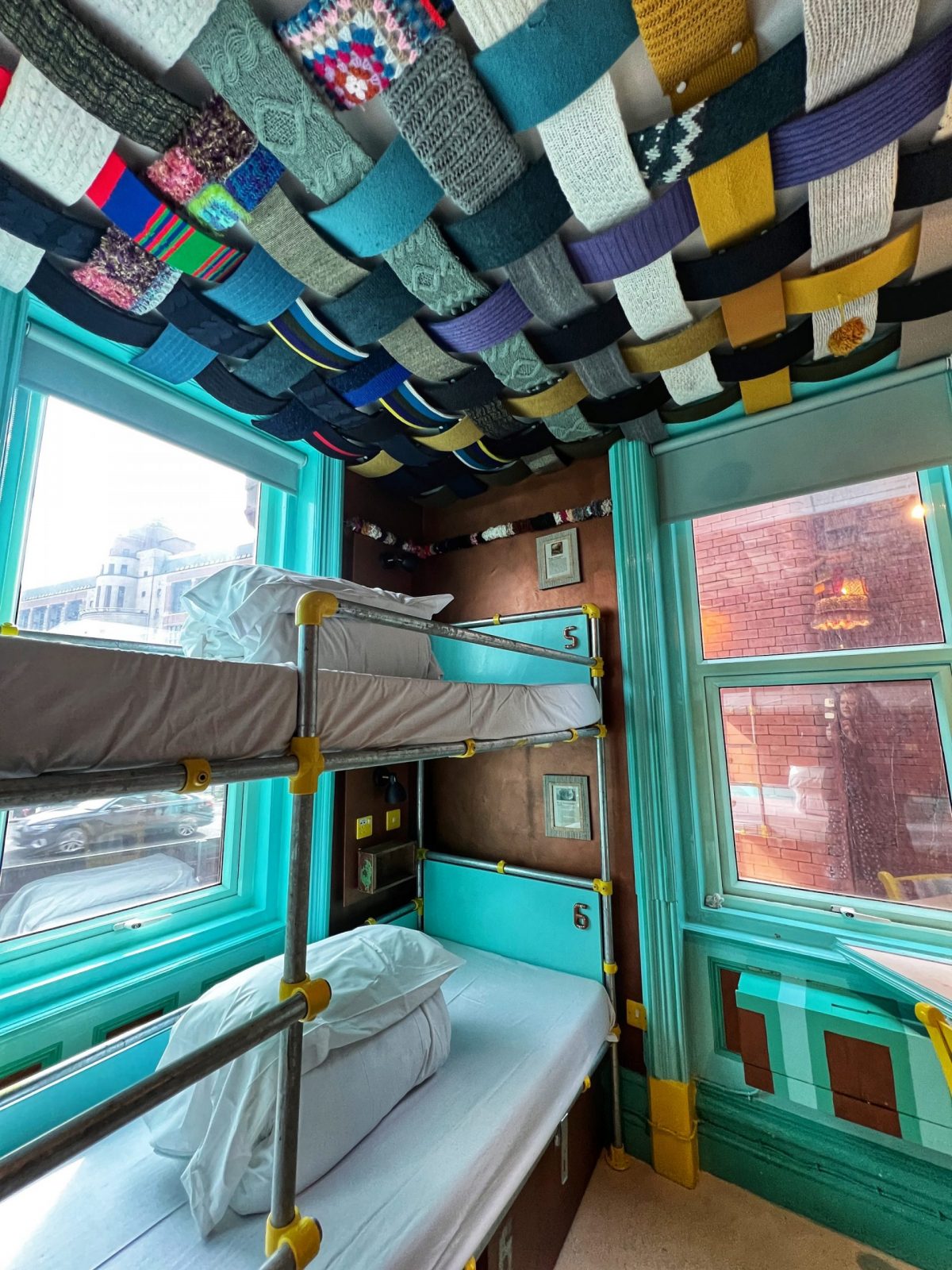A bunk bed in a room with turquoise walls. 