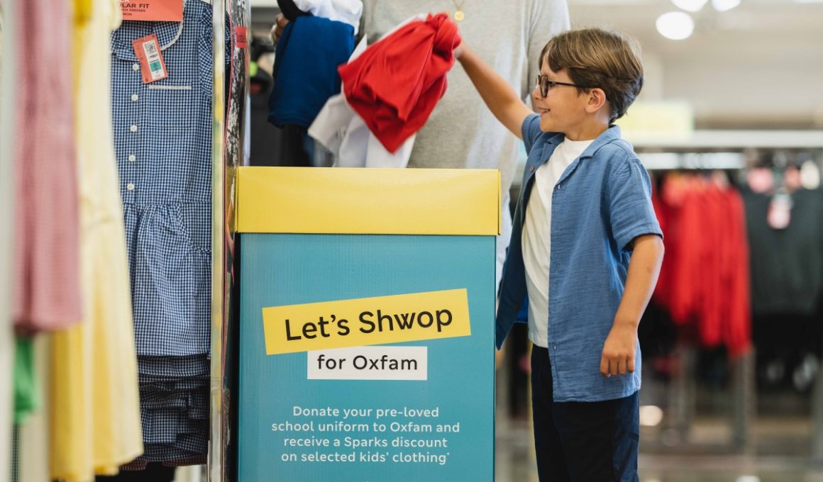 A young boy donating clothes to Oxfam in M&S.