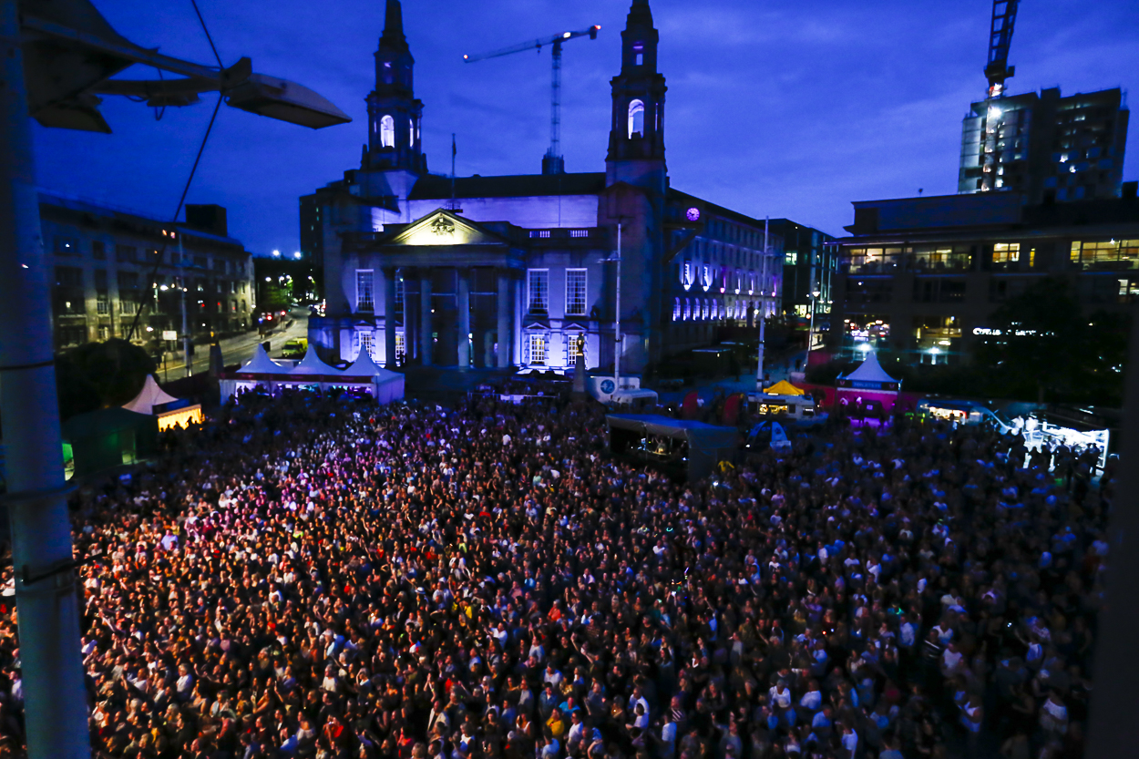 People crowded round a stage at Millennium Square.