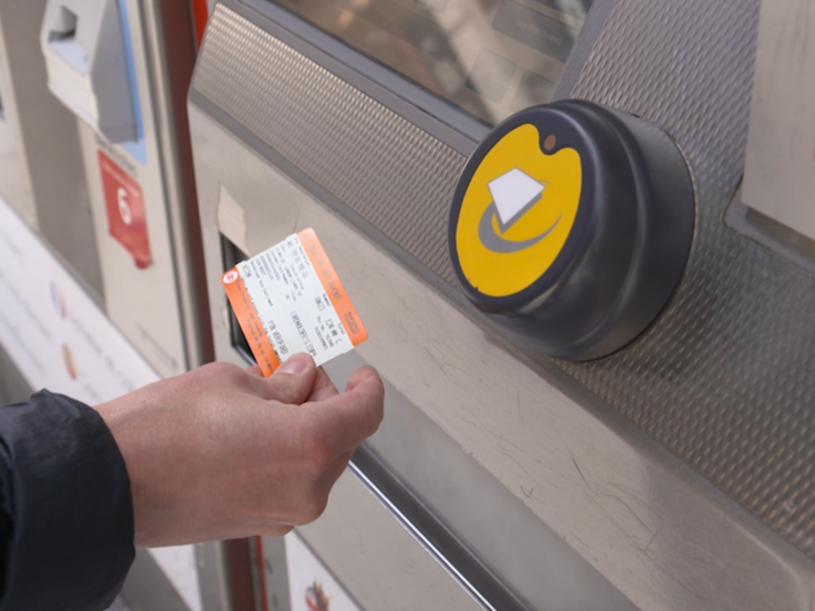 Someone tapping their train ticket through the electric barrier. 