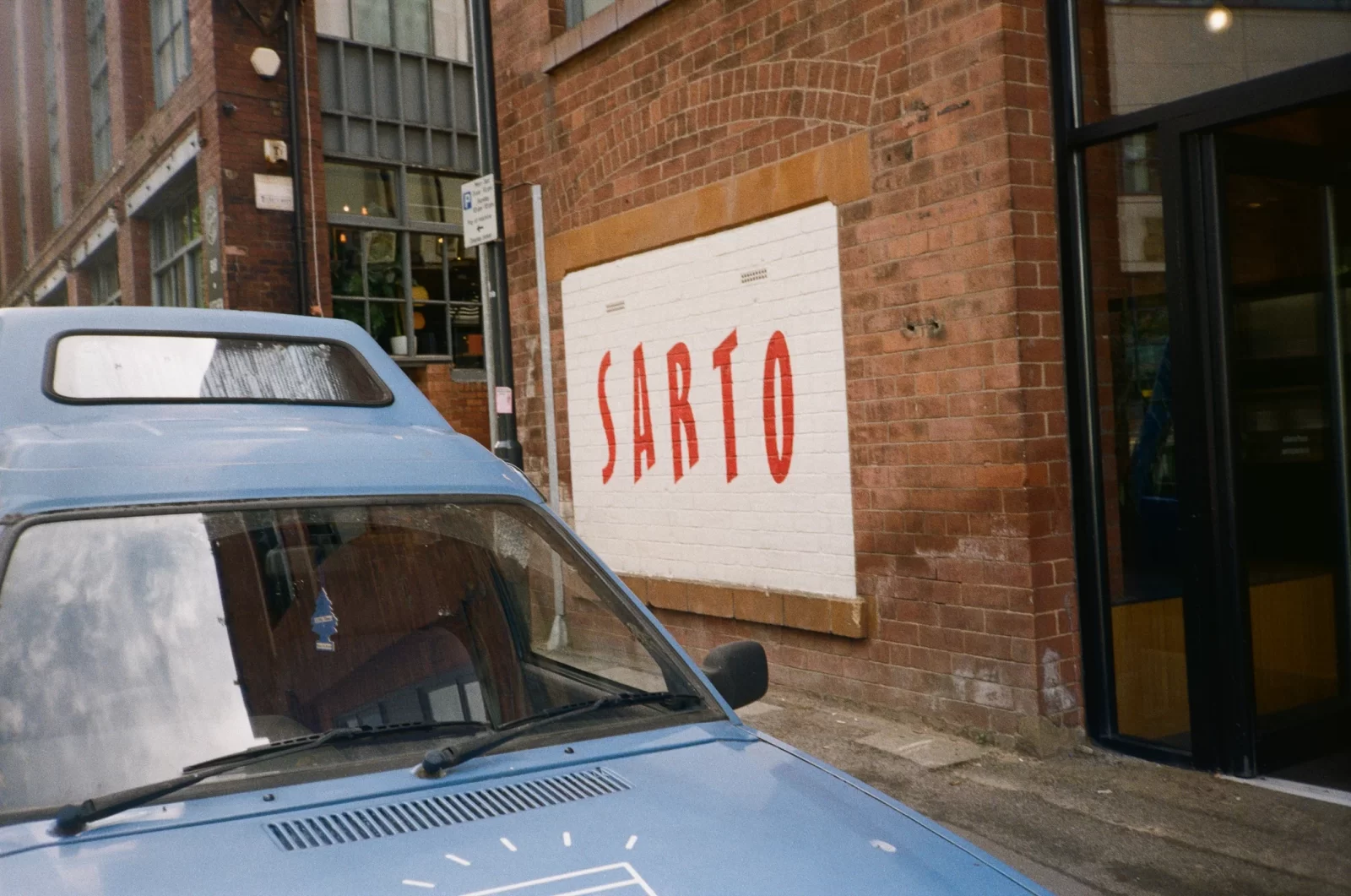 brick will with 'sarto' painted in red.