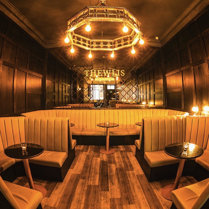 seating inside bar with gold lighting.