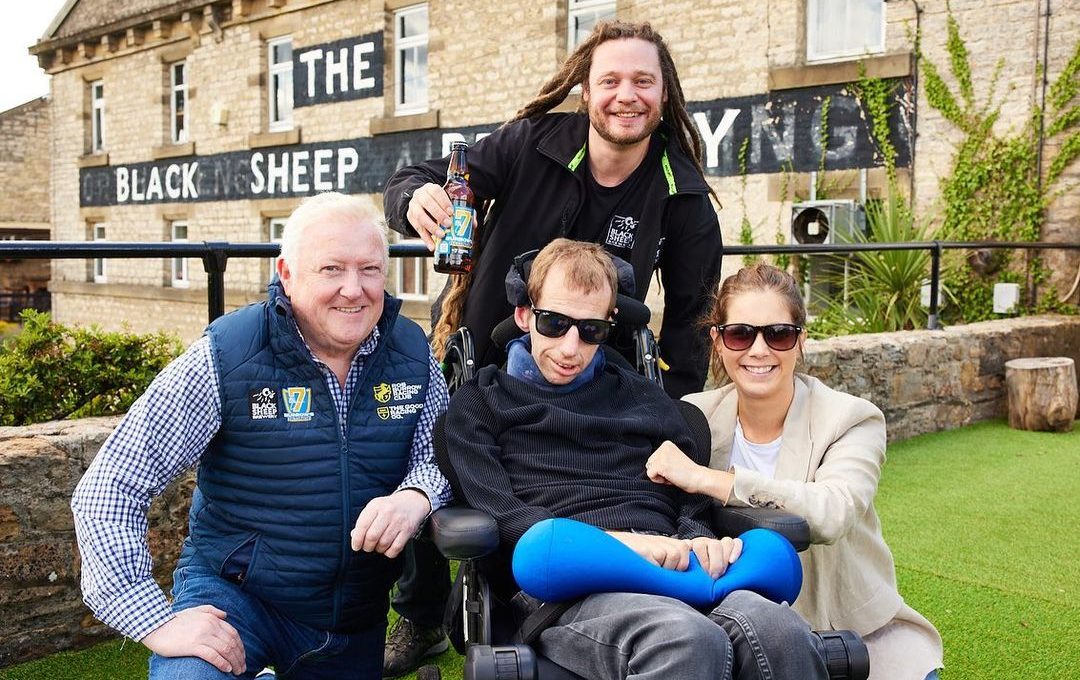 four people sat crowded around Rob Burrow.