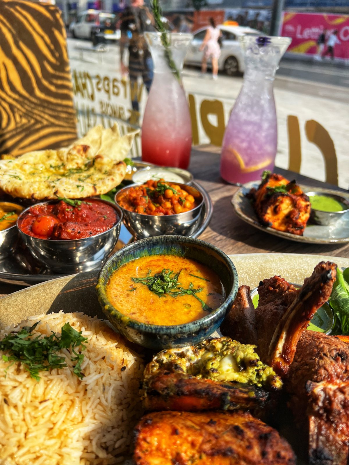 plates with different curries on and a bowl of rice.