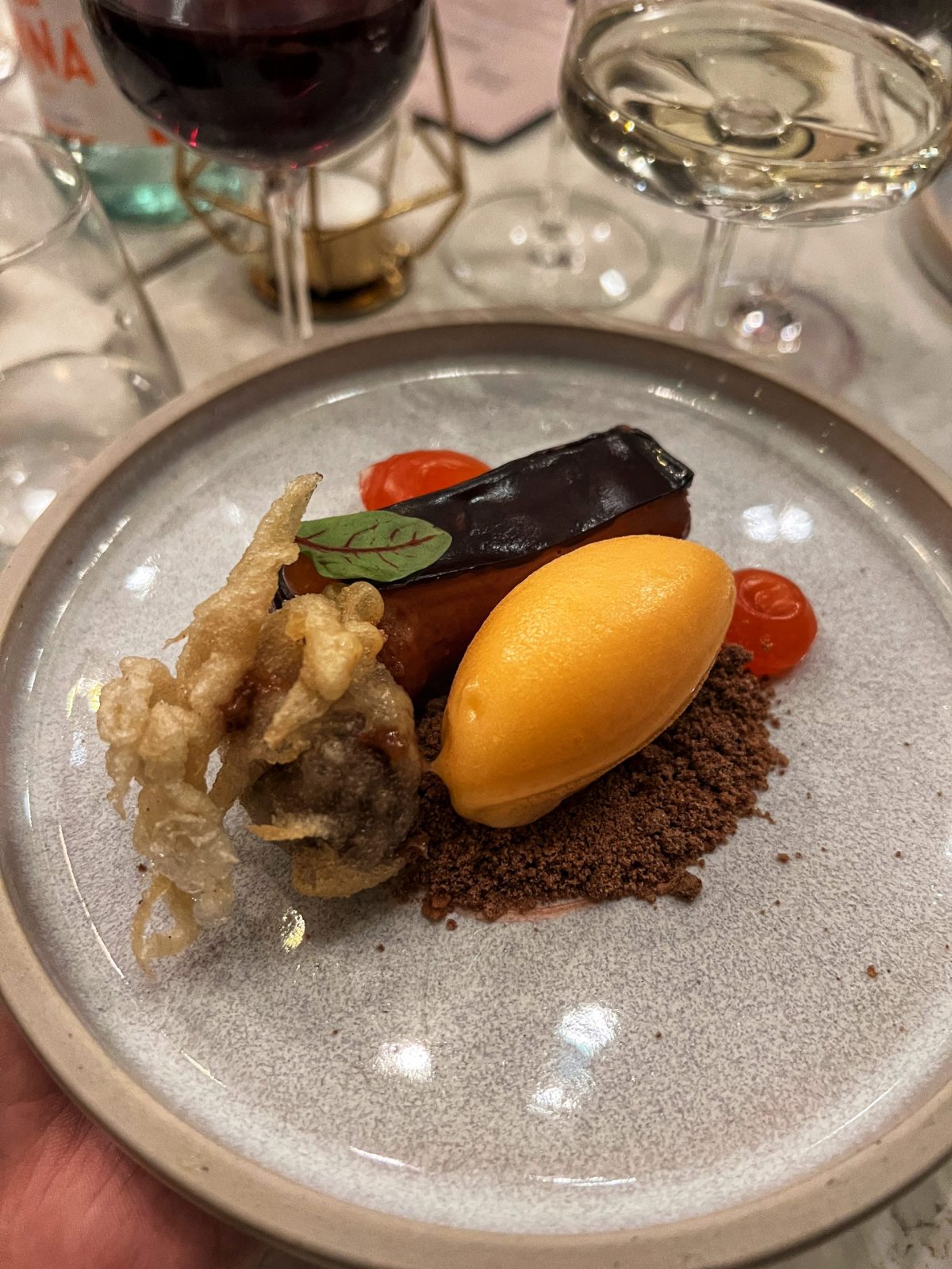 irn bru ice cream with chocolate sprinkles on a grey plate.