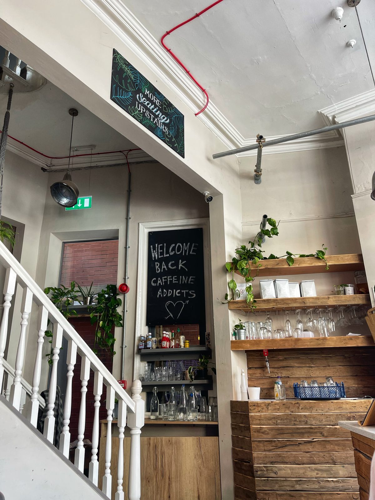 chalkboard sign that reads 'welcome back caffeine addicts' on a wall.