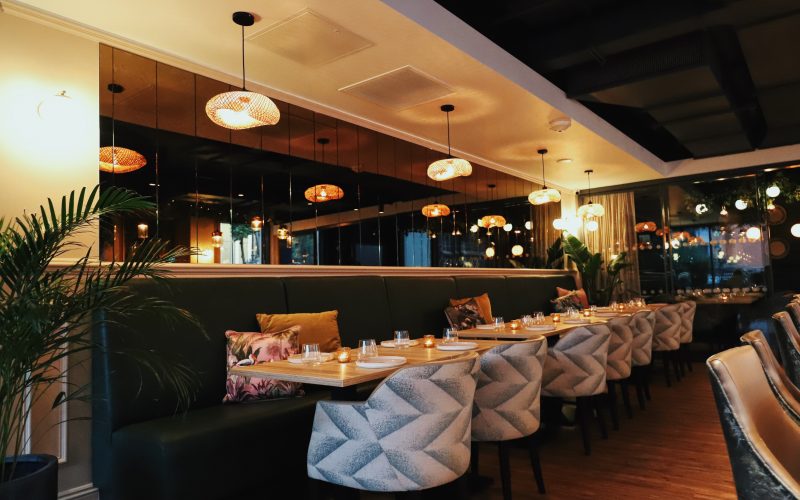 five sofa chairs with tables set inside restaurant.