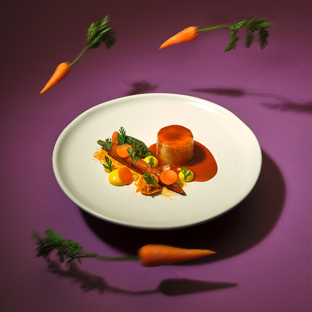 Sole Ballotine, Tandoori Baked Carrot, Carrot Top Pesto, Lobster Jus and flying carrots around the plate.