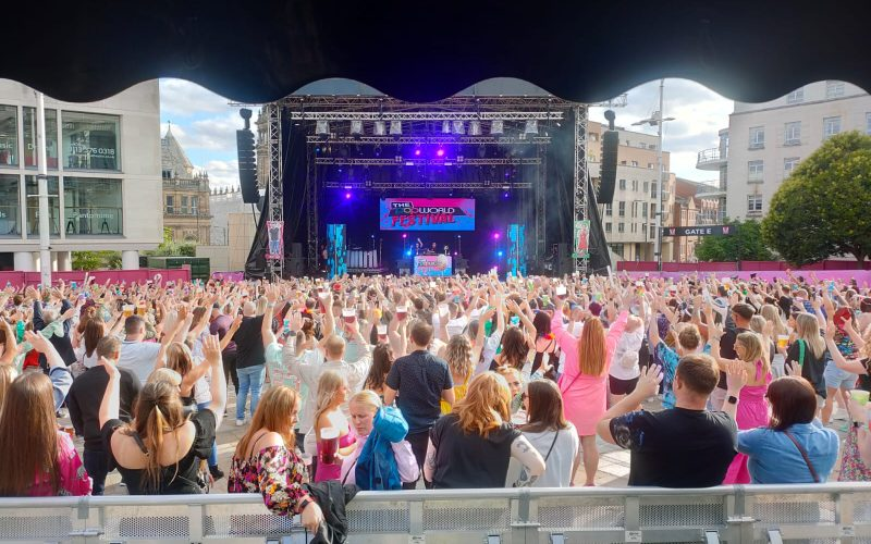 A huge crowd watching live music on an outdoor stage.